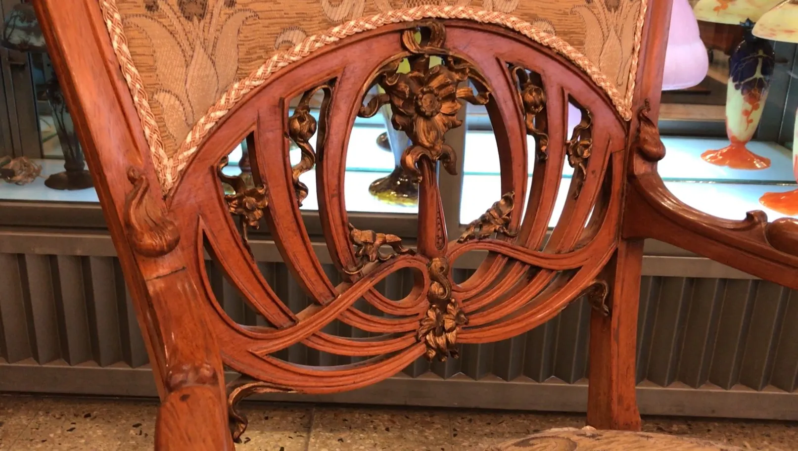 Tres sillones antiguos con tallados decorativos en el respaldo, estilo Art Nouveau, en un ambiente clásico.