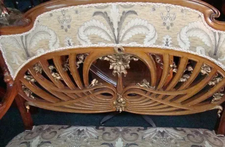 Três poltronas antigas com design ornamentado e estofamento elaborado, em um ambiente clássico.