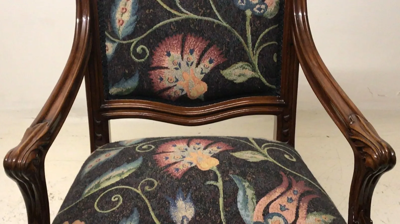 Trois fauteuils anciens avec une tapisserie florale.