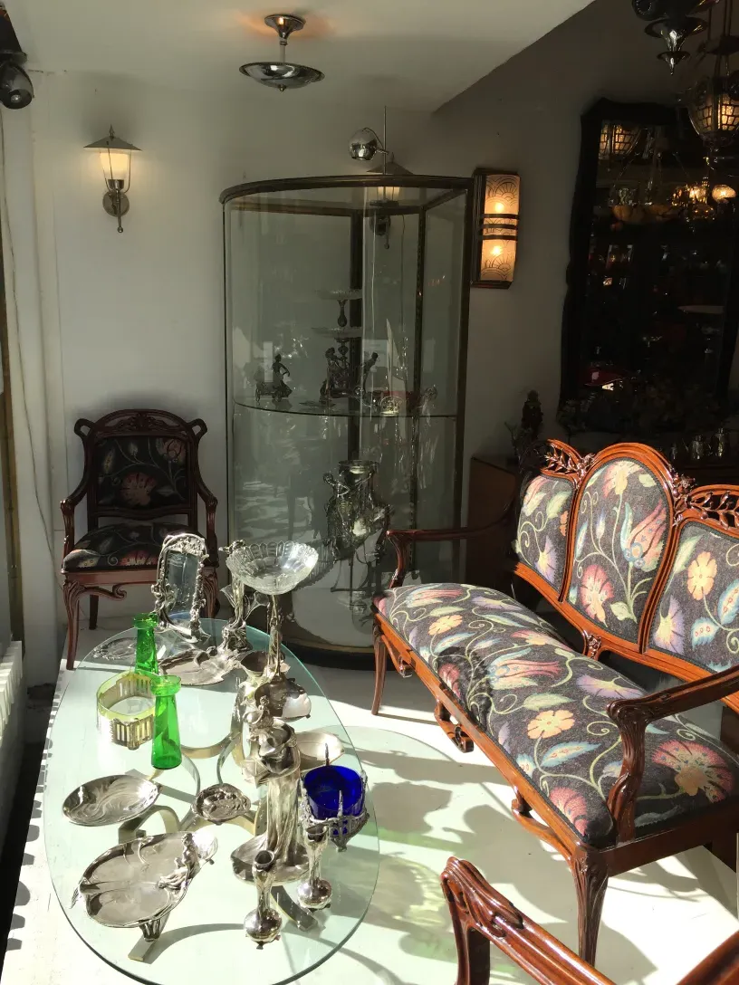 Trois fauteuils anciens avec un motif floral dans un cadre accueillant.