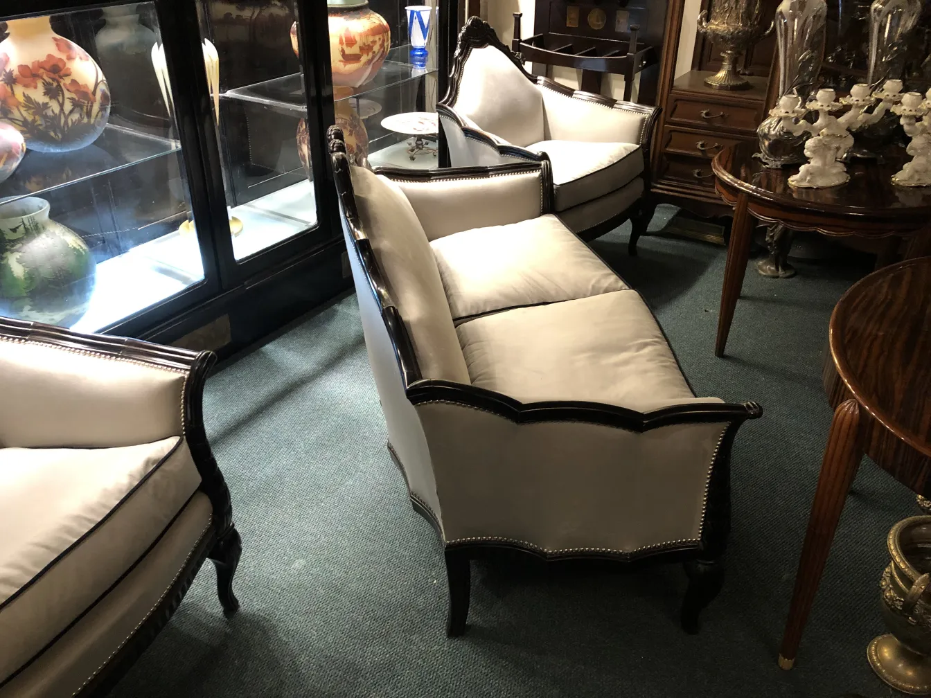 three antique armchairs with light cushions in a classic setting