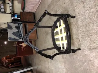 Three antique armchairs with decorative design in a shop setting