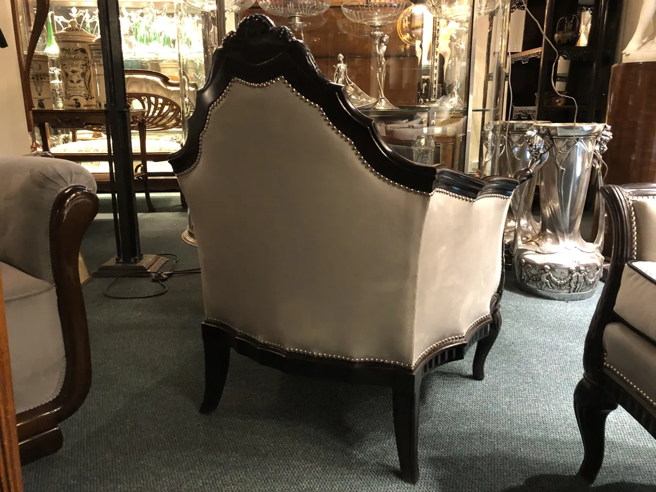 Three antique armchairs with elegant design, adorned in a classic setting.