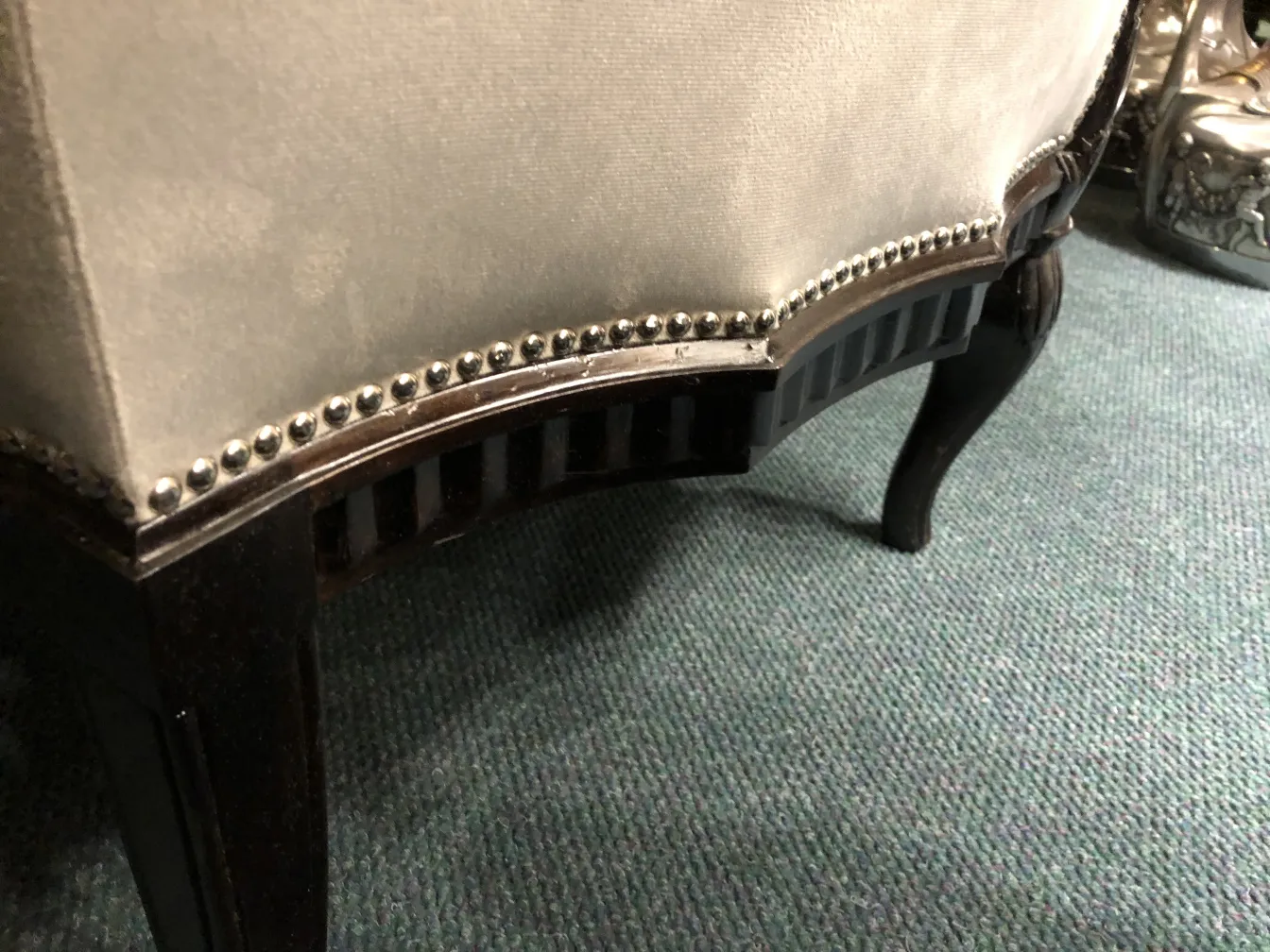 Três poltronas antigas com detalhes na frente, parte de um ambiente elegante.