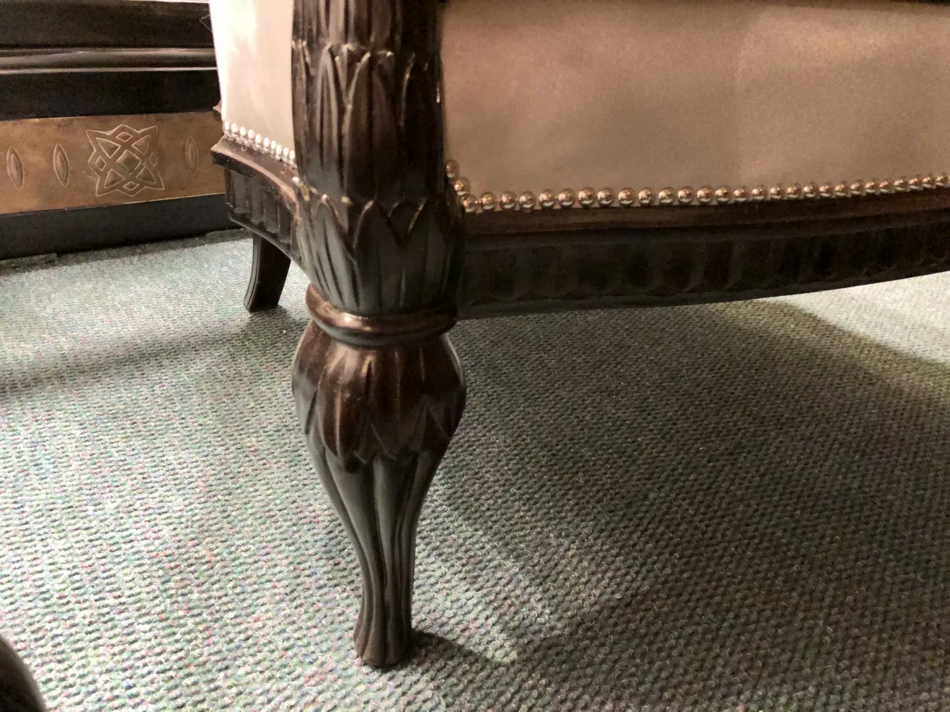 View of three antique decorative armchairs in an elegant setting.