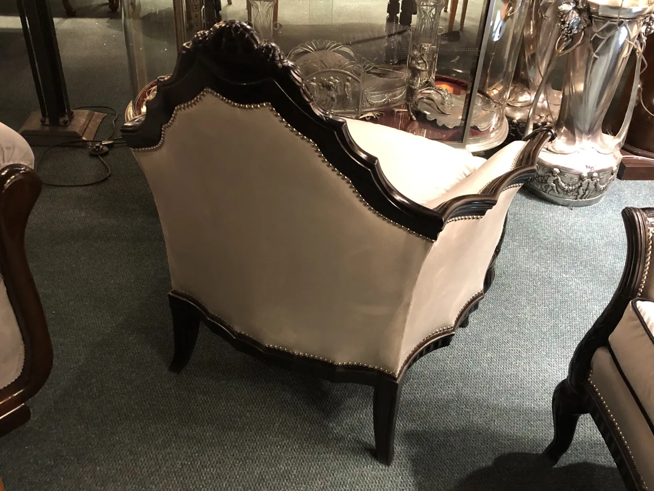 Three antique armchairs with detailed backrest in classic setting.