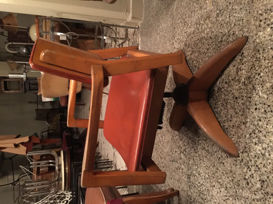 Sillón de escritorio antiguo con base rodante, ambiente de antigüedades