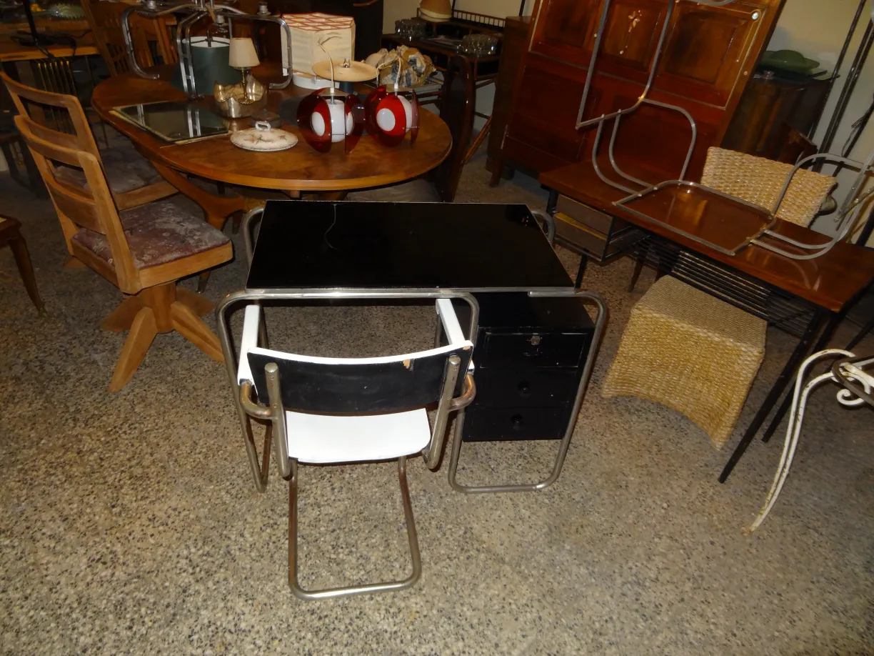 Fauteuil de bureau antique en noir et blanc, entouré de meubles vintage dans un cadre chaleureux.