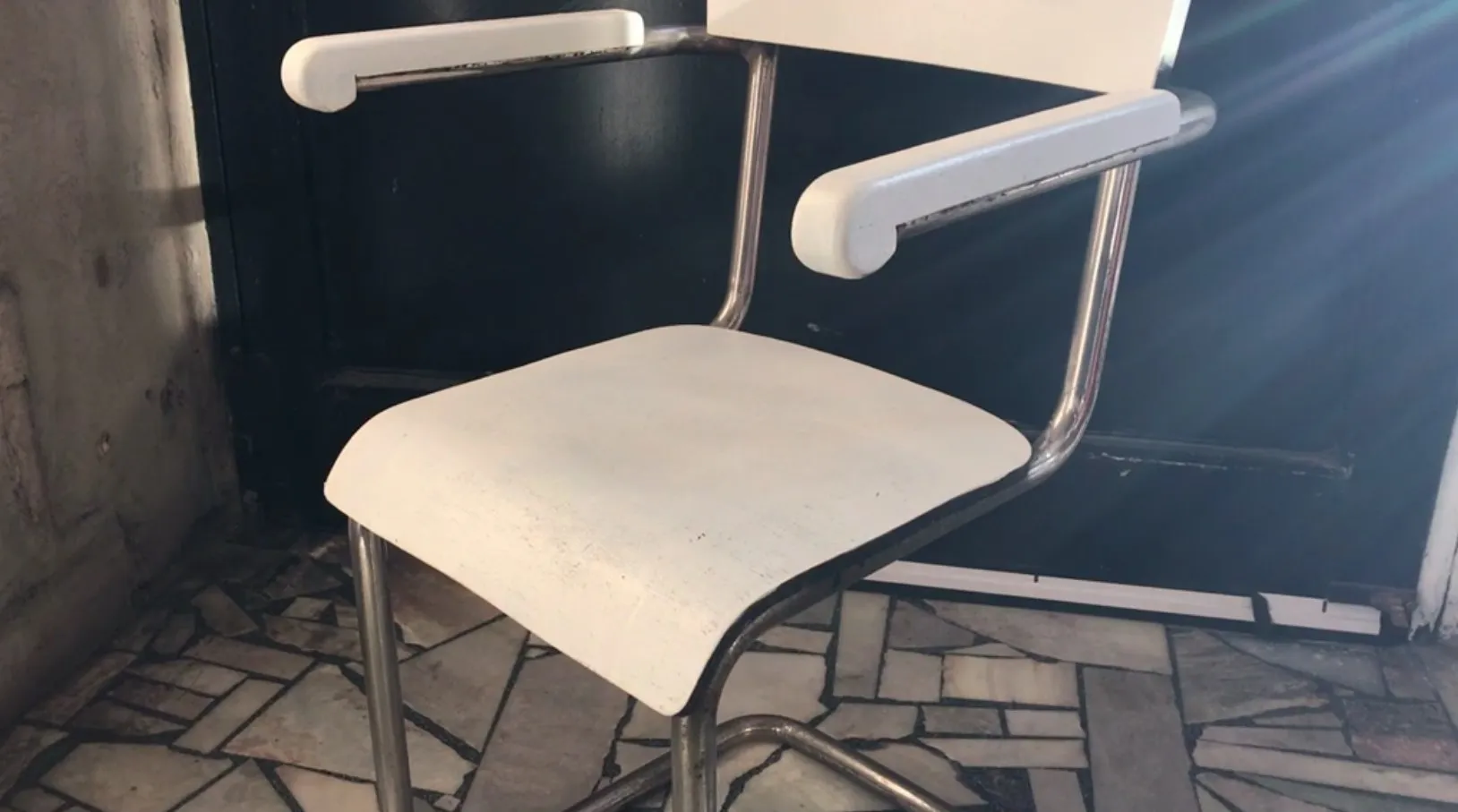 sillón de escritorio antiguo con color blanco y diseño elegante en un entorno con paredes de piedra