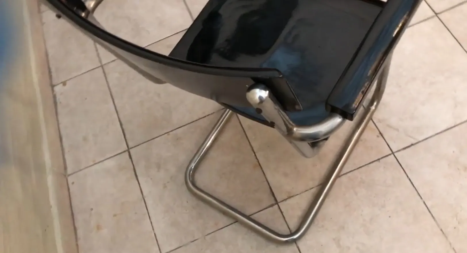 sillón de escritorio antiguo con superficie negra y patas metálicas