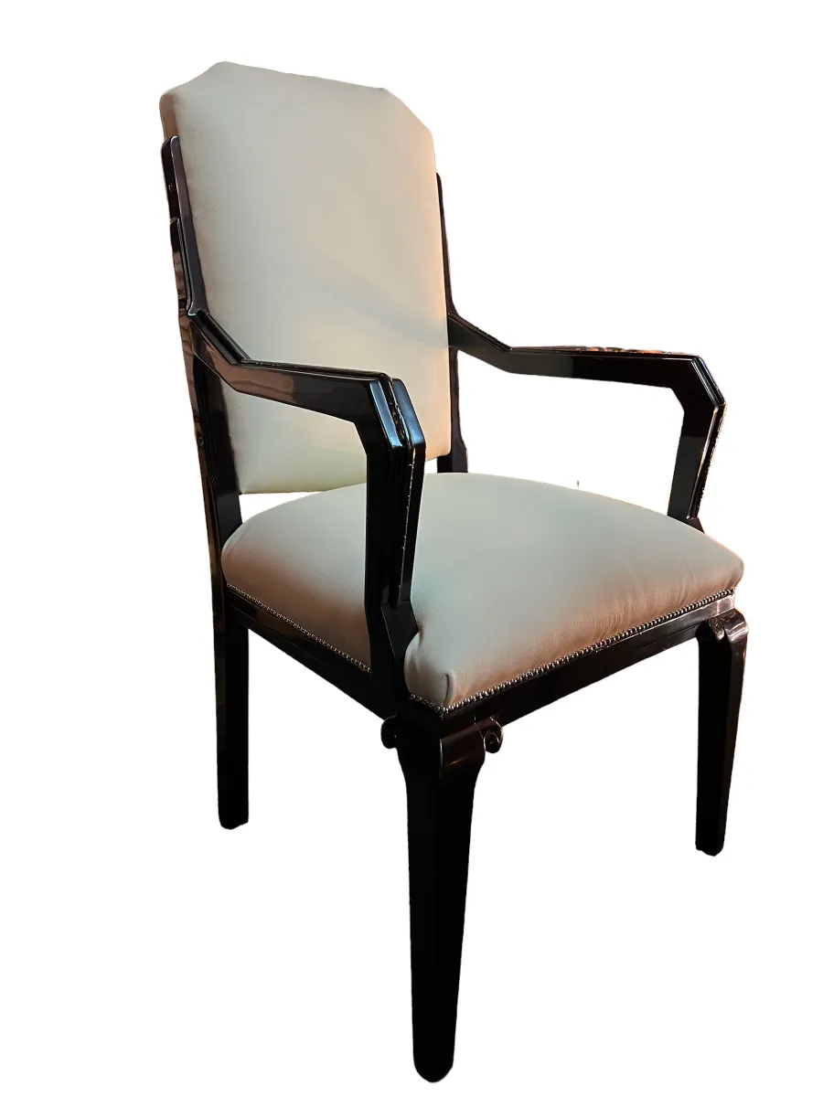 Antique desk chair with padded seat and arms, in an elegant setting.