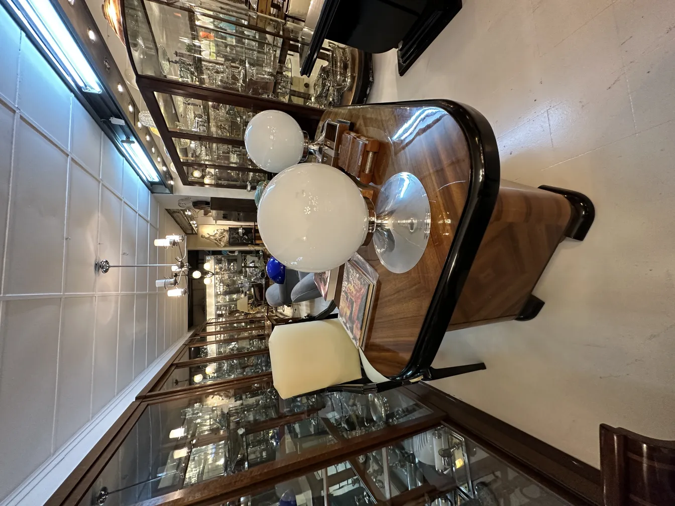 Antique desk chair in a decorative setting with lamps and display cases.