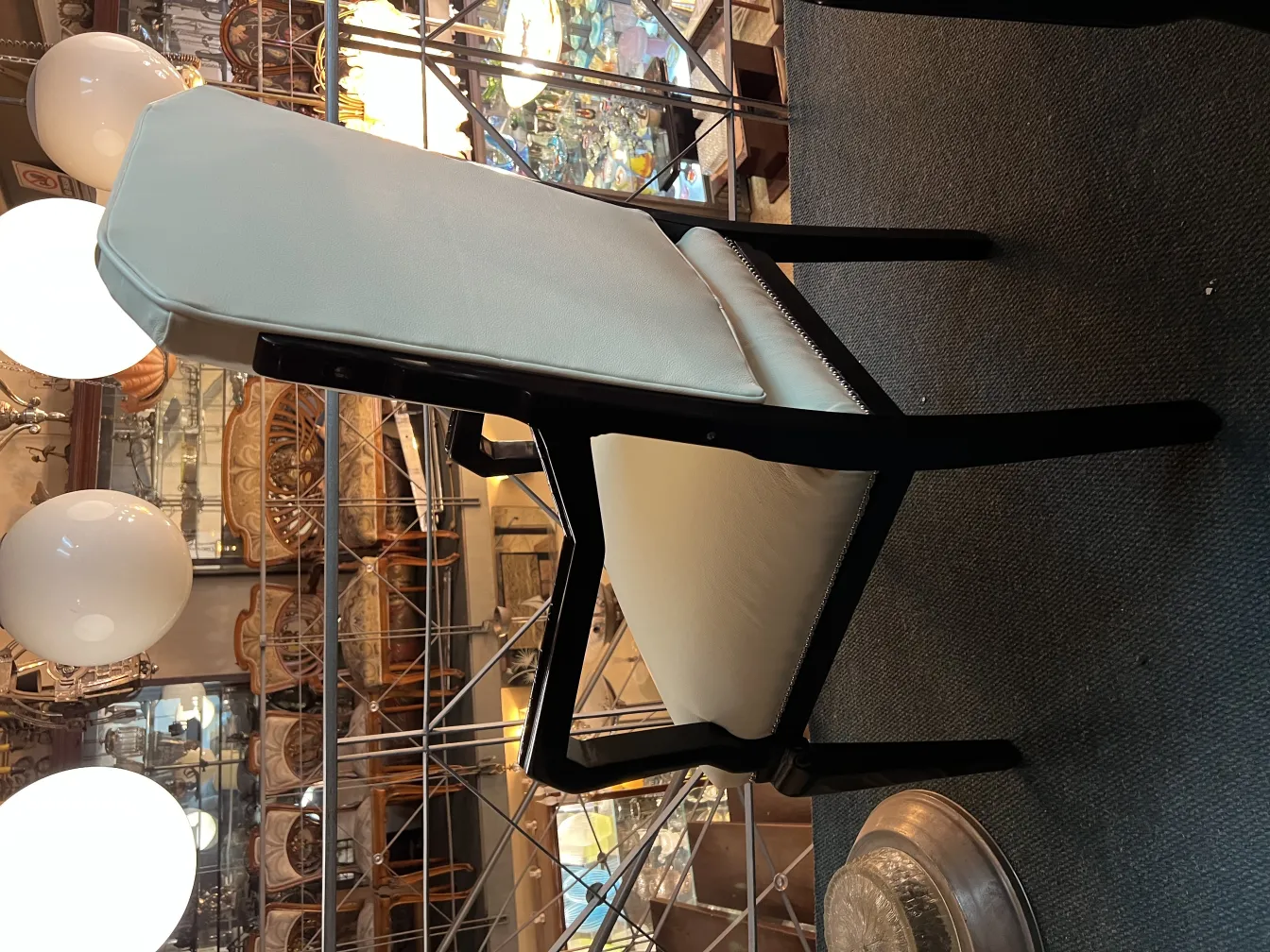 Poltrona da ufficio antica in un ambiente decorativo con luci e oggetti vintage.