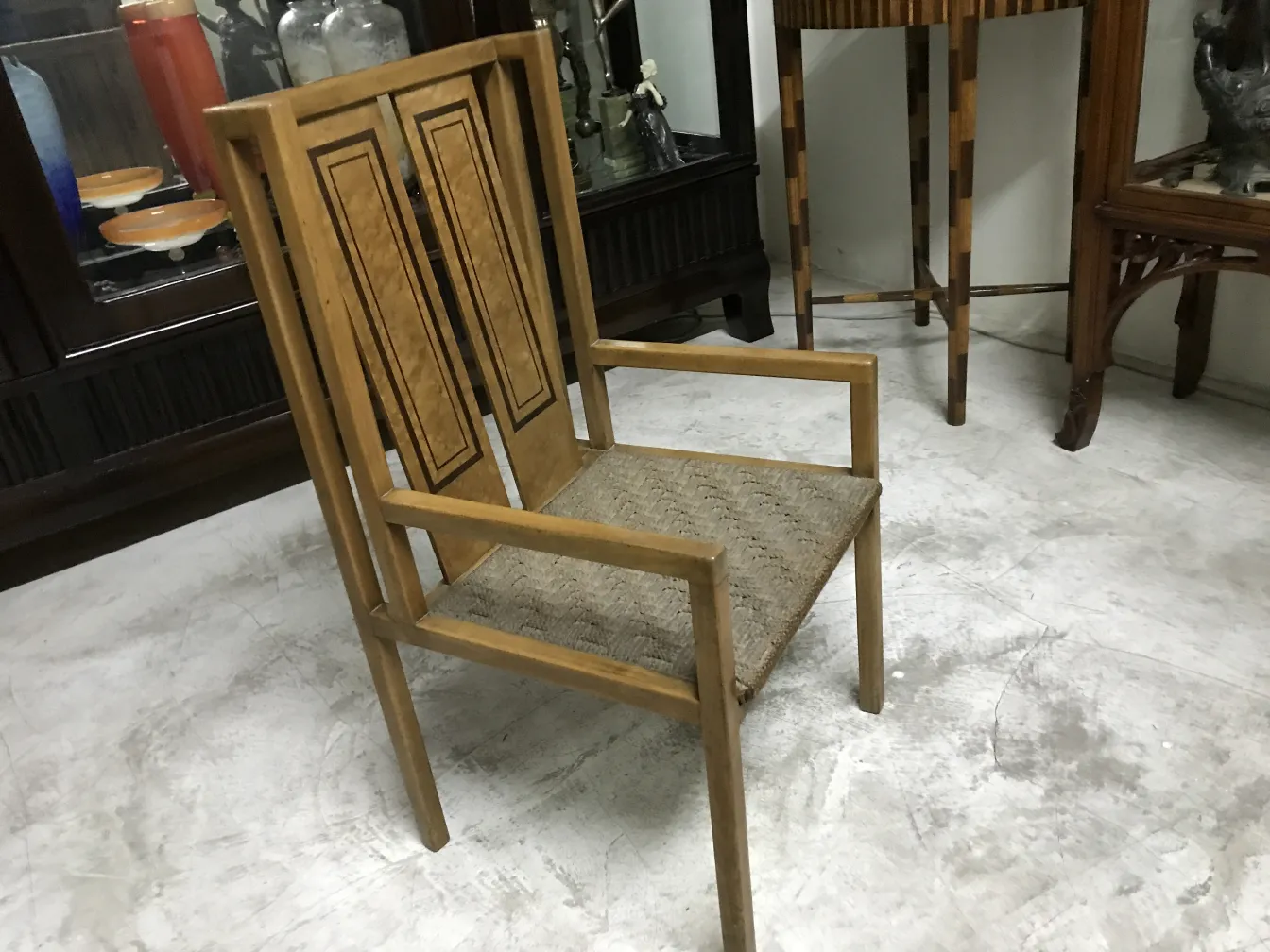 Antique desk chair with high back and unique design in an elegant setting.