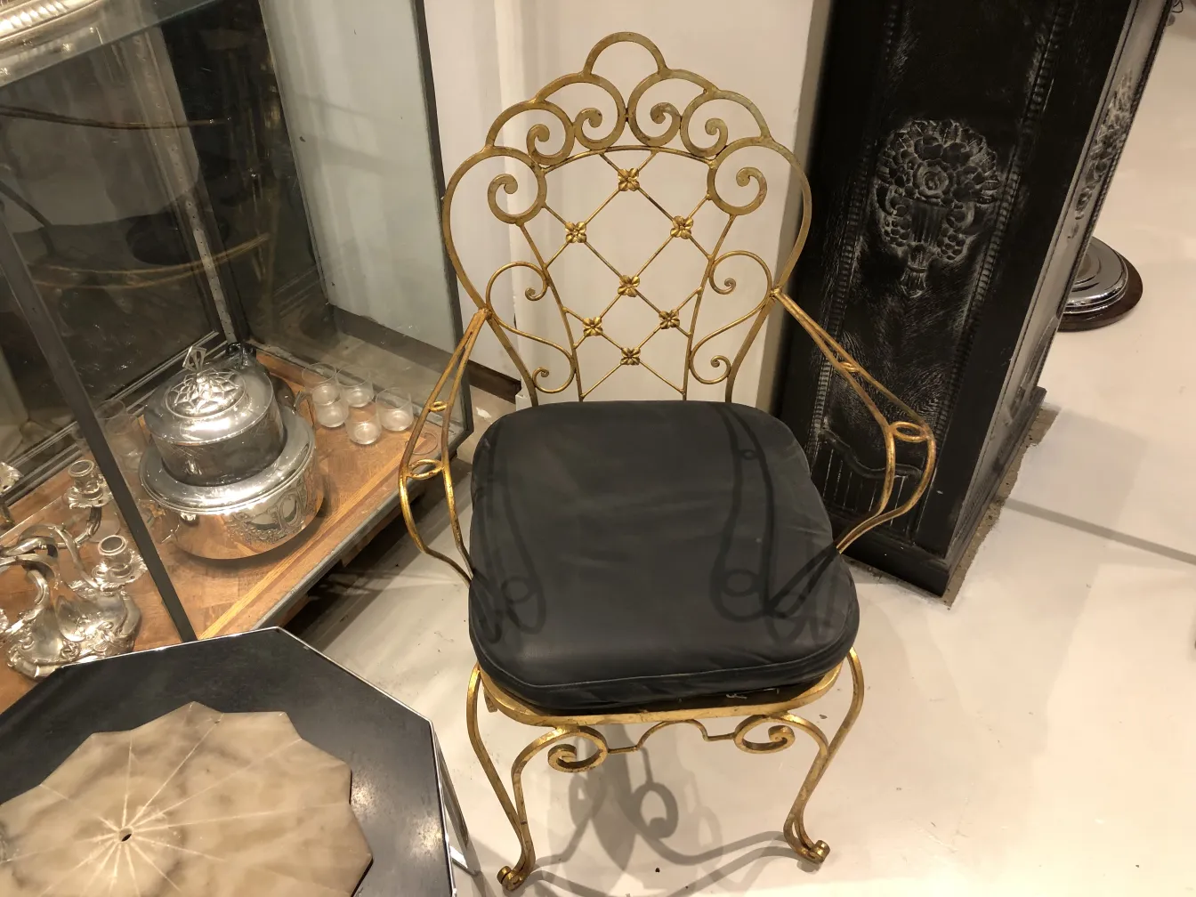 2 antique chairs with ornate design and black cushion