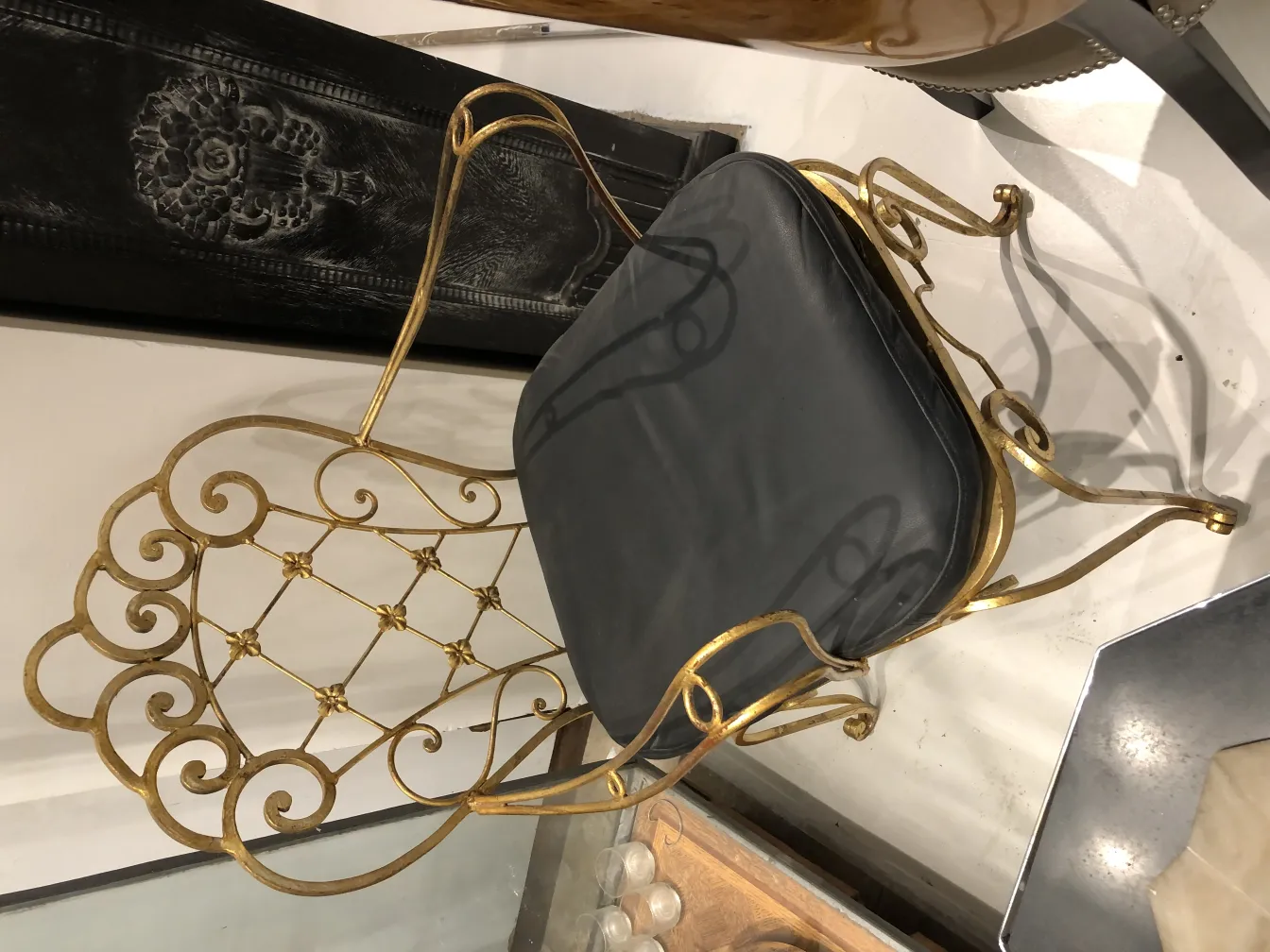 Due sedie antiche con design decorativo in un ambiente elegante, con dettagli dorati.