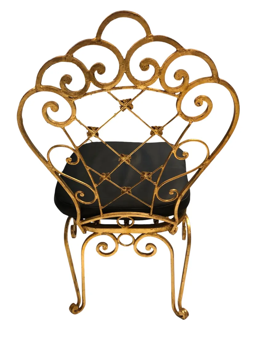 Rear view of two antique chairs with decorative design, neutral background.