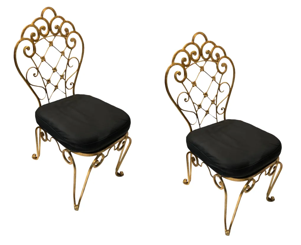 2 cadeiras antigas com design decorativo e almofada preta