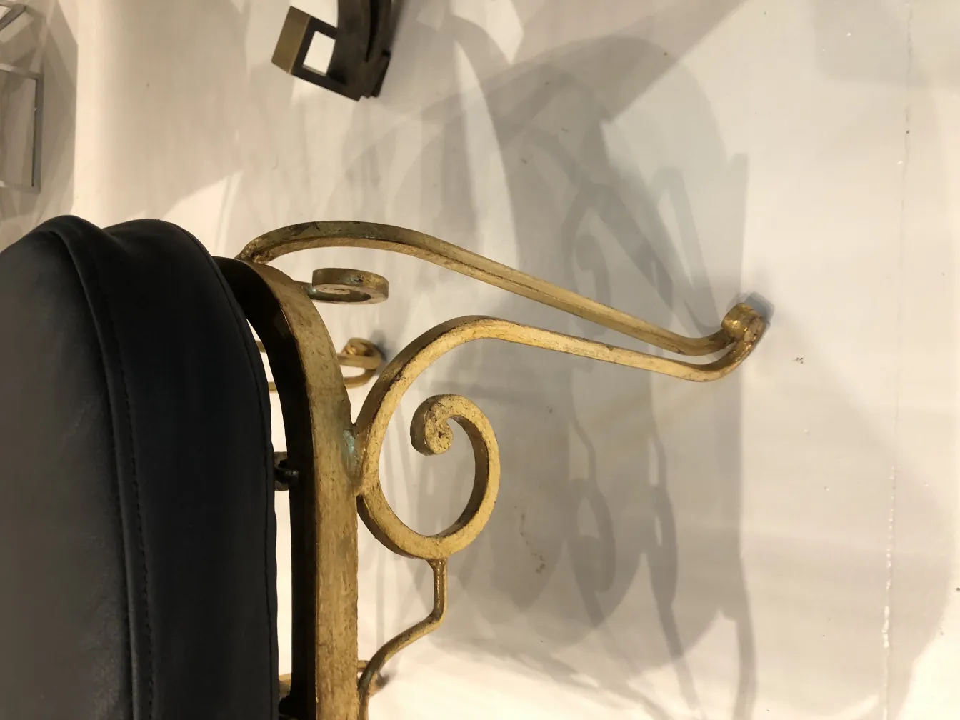Side view of 2 antique chairs with golden ornaments and black backrest