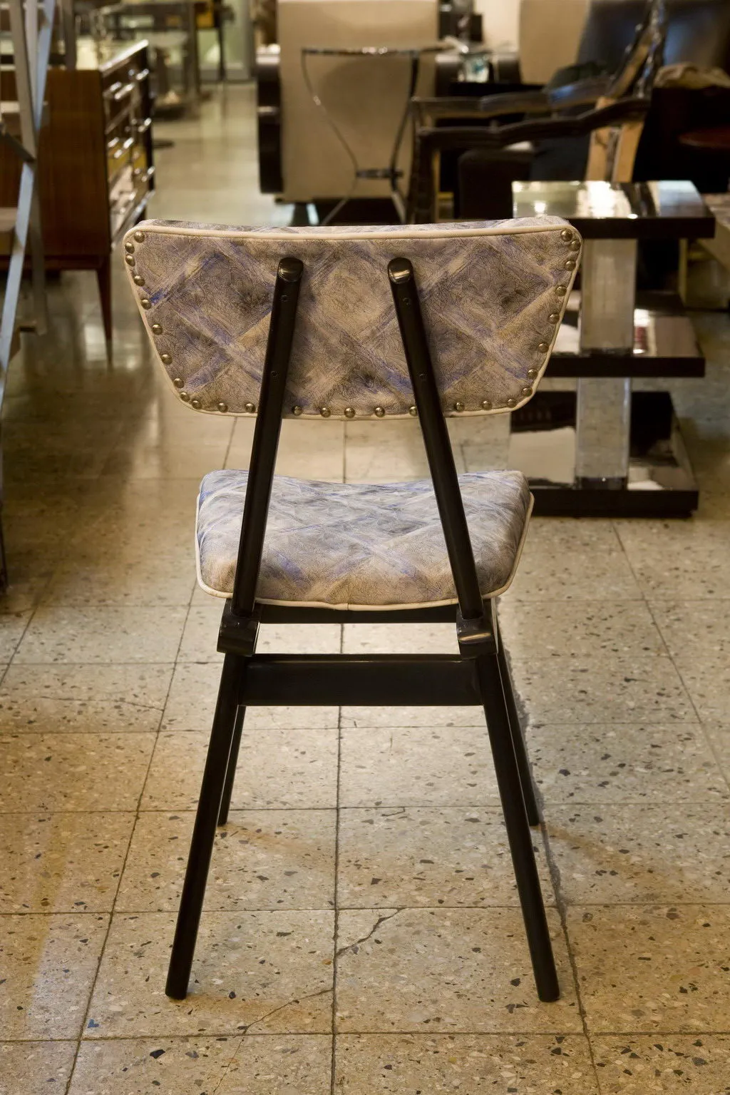 Chaises anciennes avec rembourrage en exposition, fond moderne.