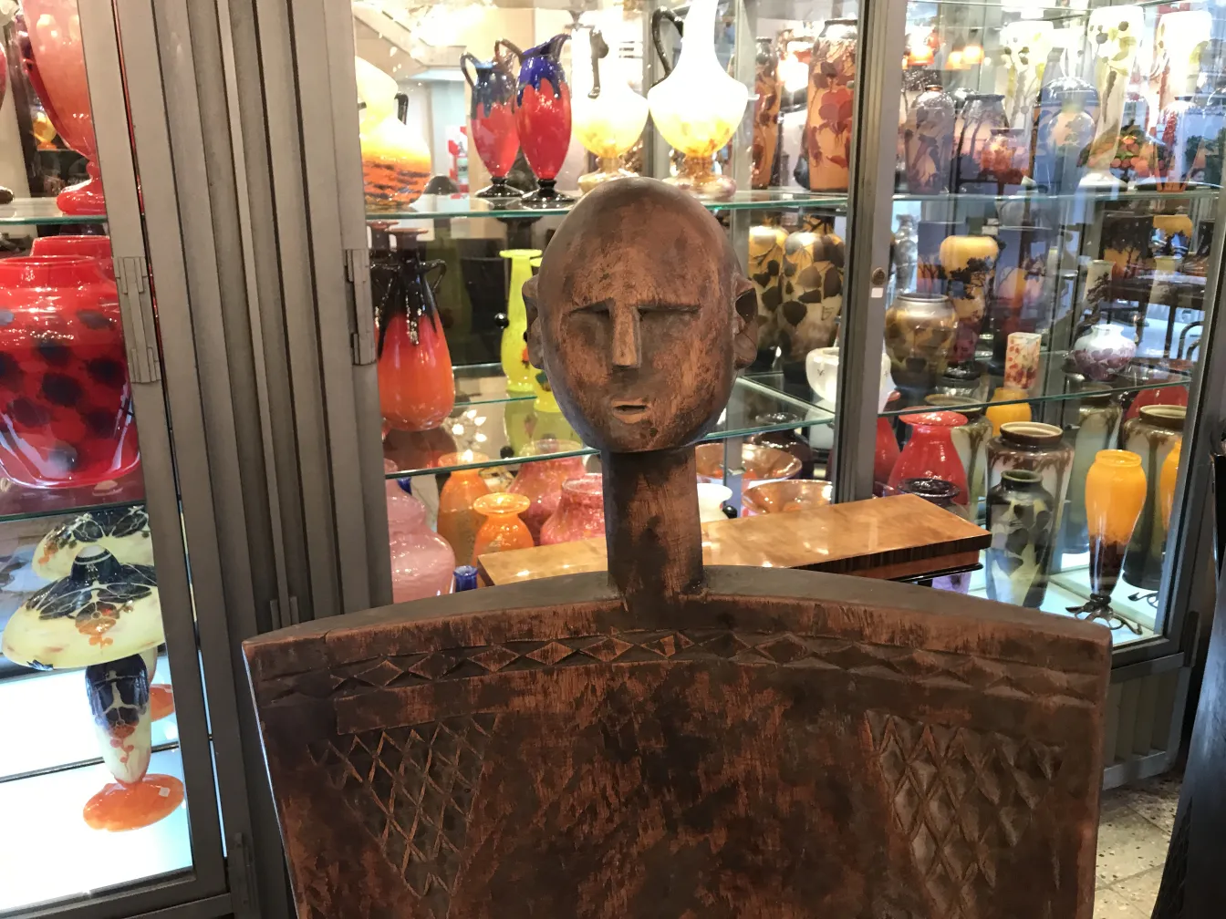 2 sedie antiche con design decorativo in una galleria con vasi colorati