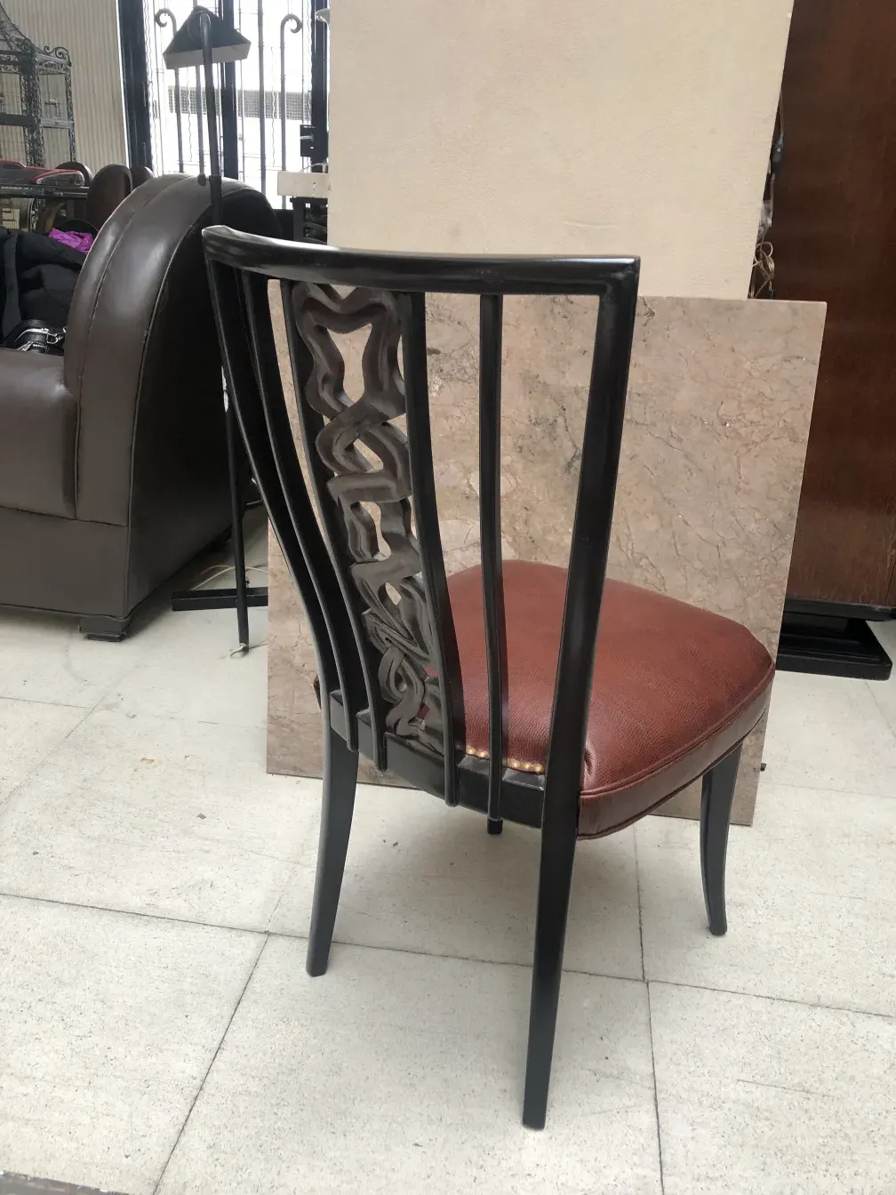 deux chaises anciennes avec un design architectural au dos, dans un environnement ensoleillé