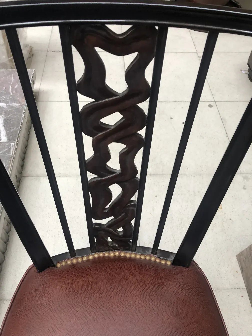 View of two antique chairs with unique details in a neutral setting