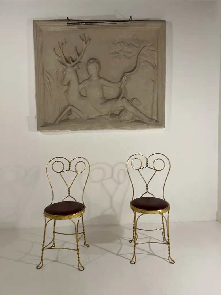 Duas cadeiras antigas com design decorativo em um ambiente minimalista