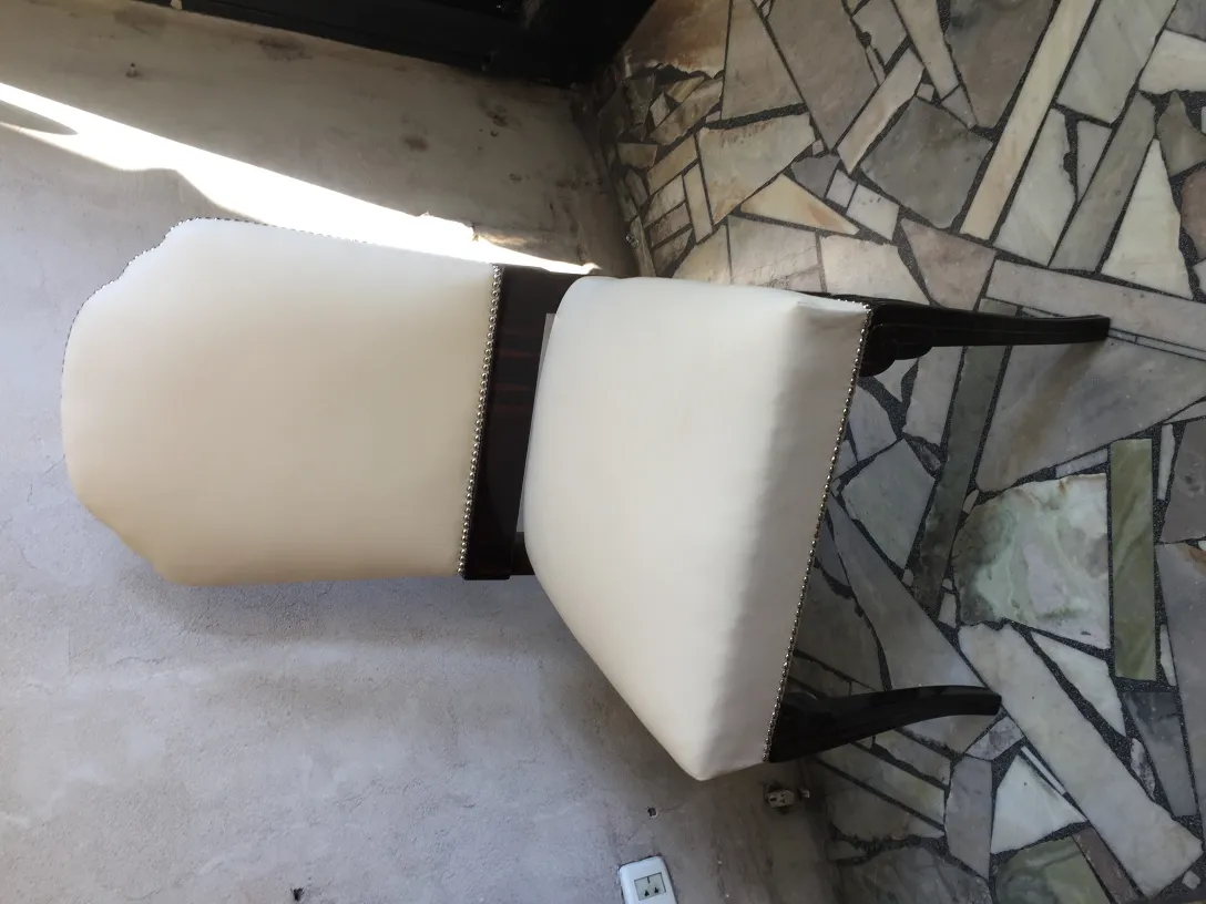 Vue latérale de 6 chaises antiques dans une pièce avec un sol en pierre.