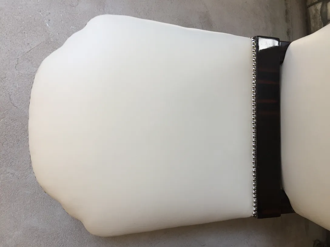 Detalhe de 6 cadeiras antigas com acabamento elegante em um ambiente neutro.