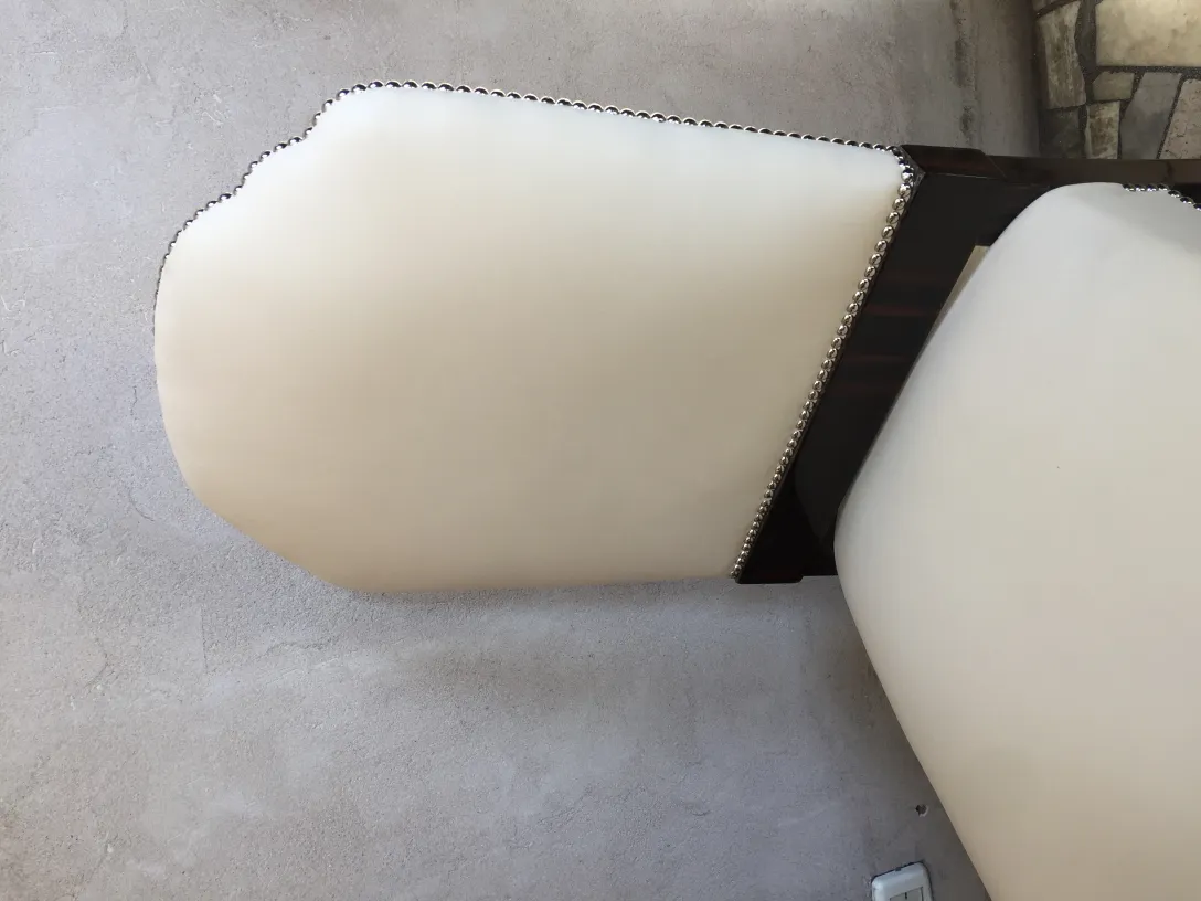 Cadeiras antigas de cor clara com detalhes decorativos