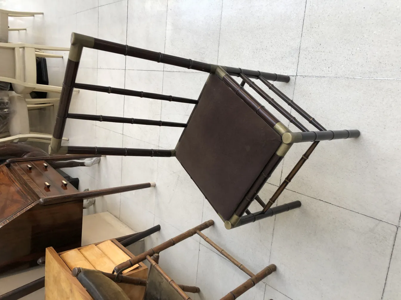 Seis sillas antiguas en un entorno de antigüedades, inclinadas y variadas.