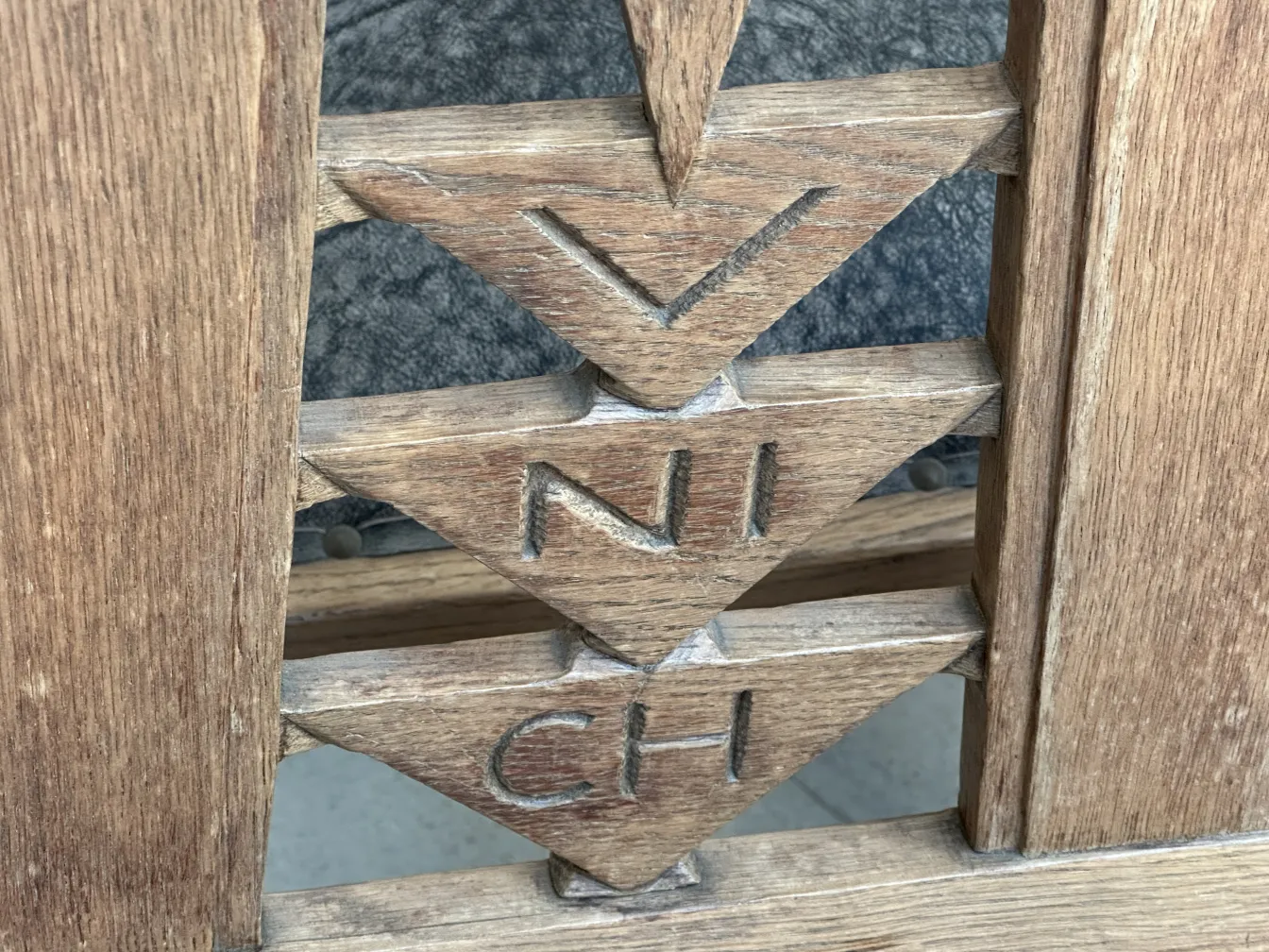 Detail of 6 antique chairs with wood carvings against a gray background.