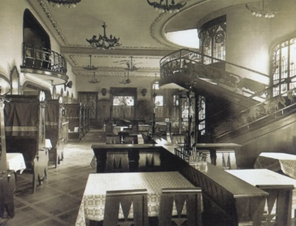 Imagem de uma sala de jantar elegante com 6 cadeiras antigas, mesas decorativas e um ambiente clássico.