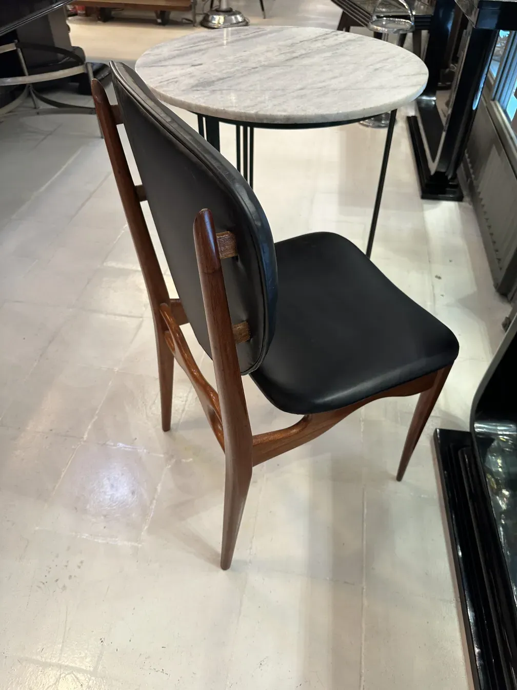 Ocho sillas antiguas con un diseño distintivo y elegante, en un ambiente moderno.