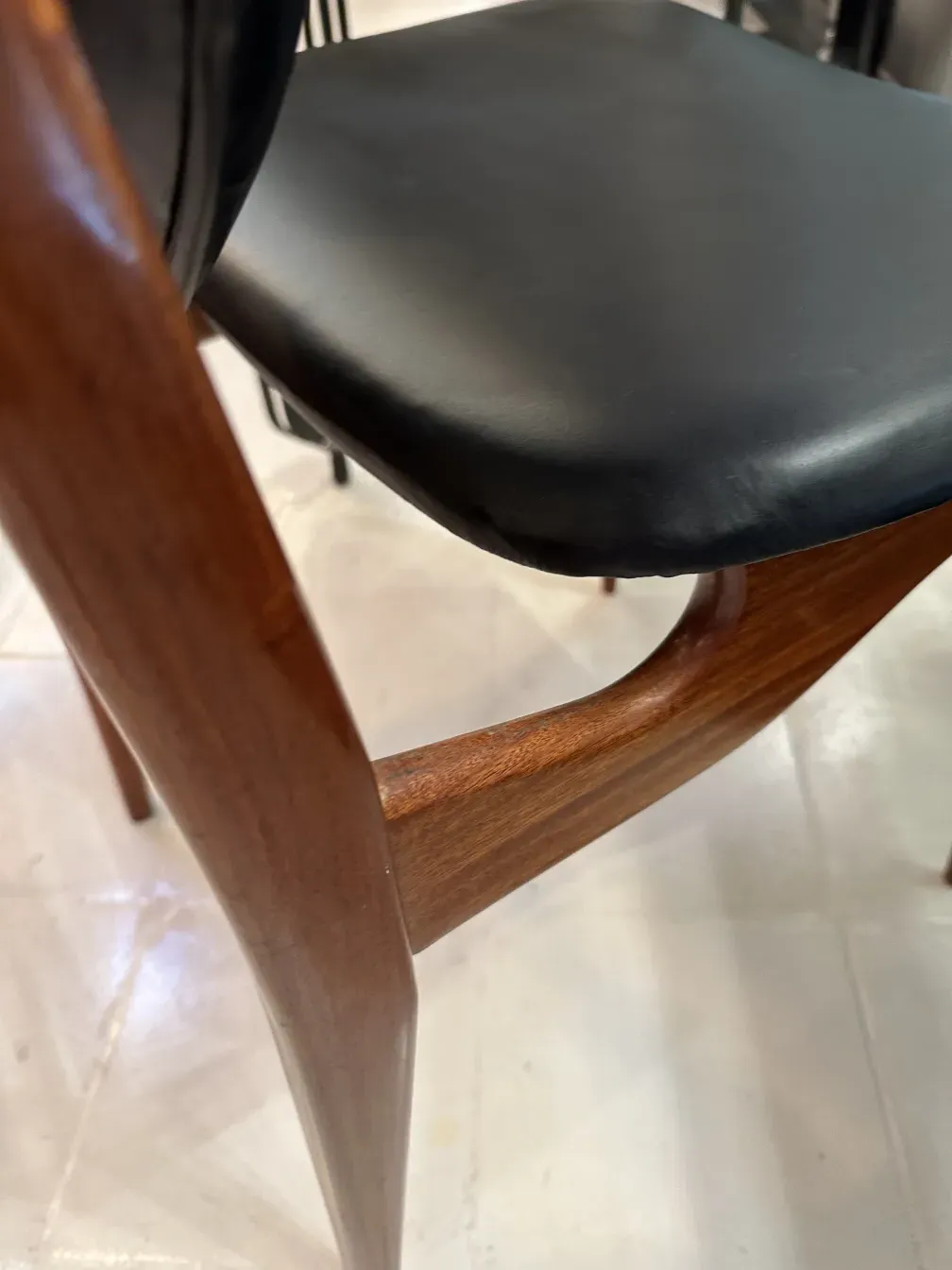 acht antike Stühle mit elegantem finn juhl Design, in einer gemütlichen Umgebung.