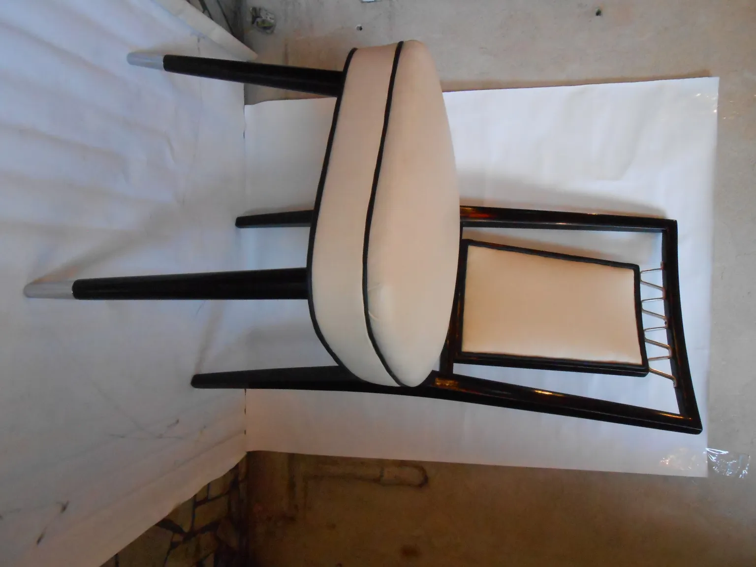 Cadeiras antigas com design decorativo em um ambiente neutro.