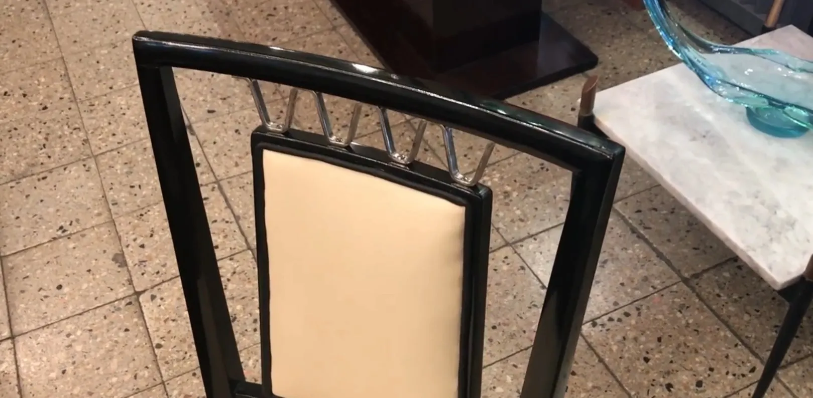 Vista dettagliata di una sedia antica con schienale elegante in un ambiente accogliente.