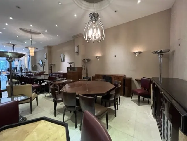 Sala com antigas 12 cadeiras em um ambiente aconchegante.