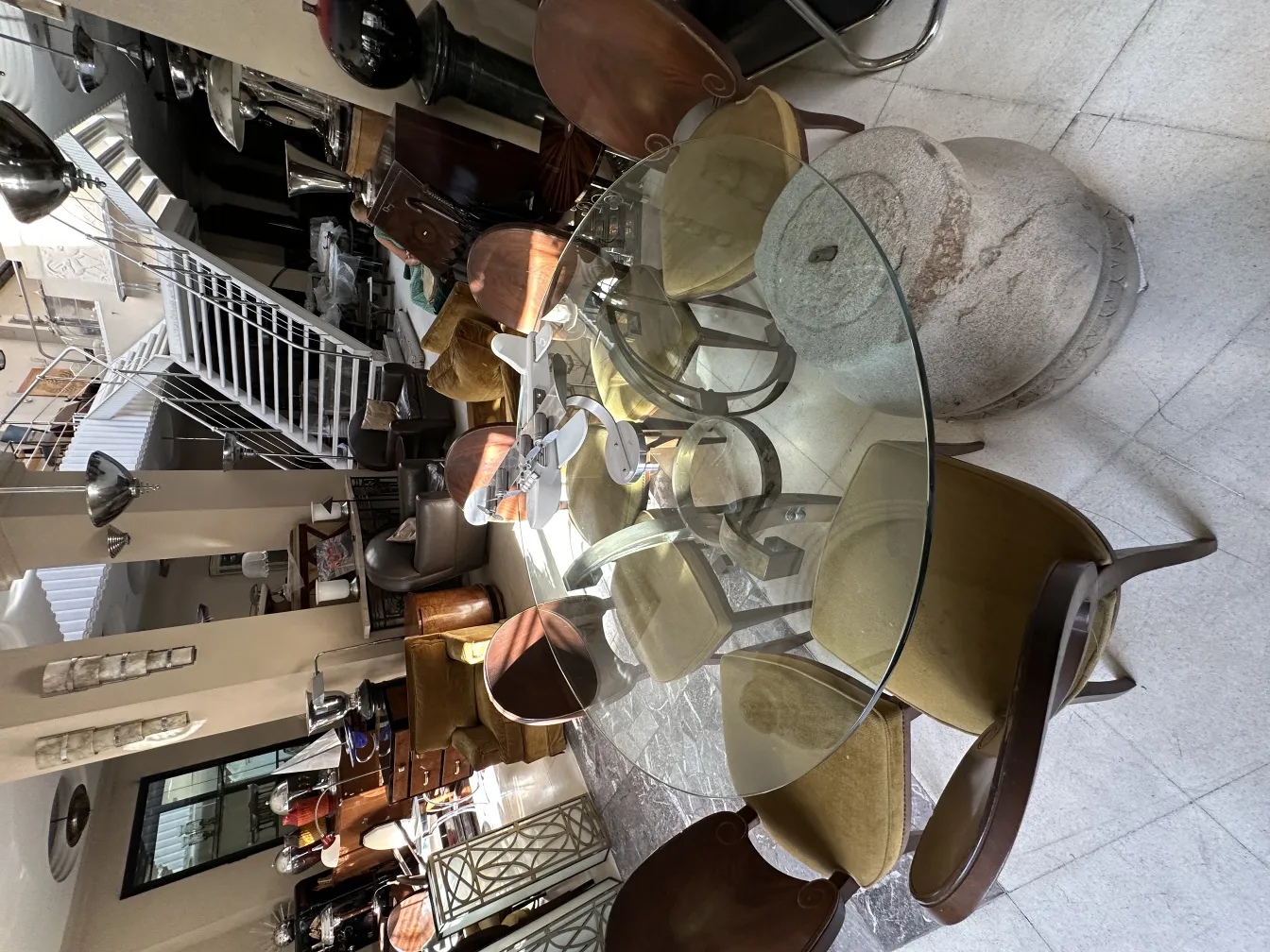 12 antique dining chairs in a spacious, bright environment with varied decor around.