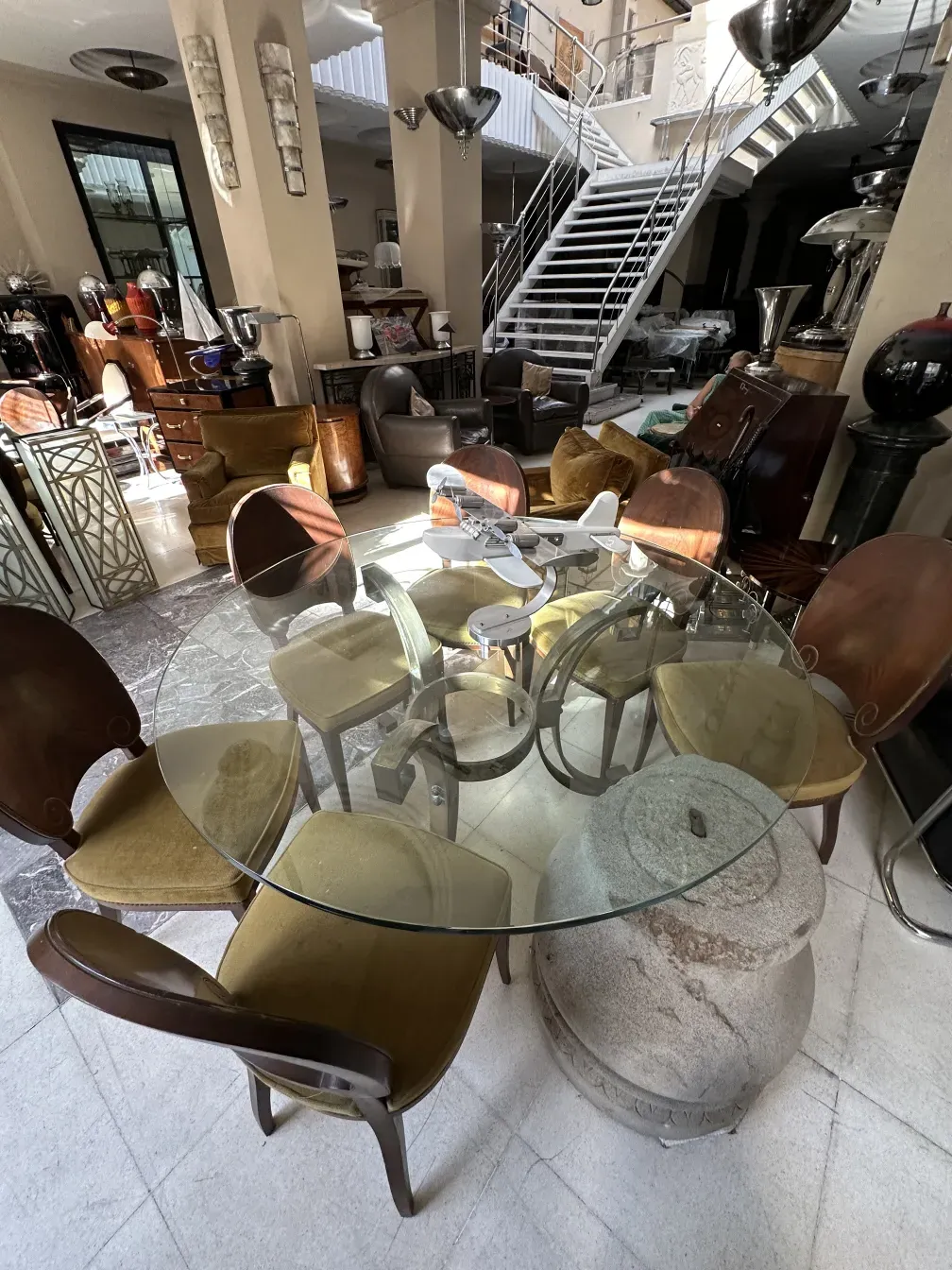 Conjunto de 12 sillas antiguas Jansen alrededor de una mesa circular, con ambiente acogedor.