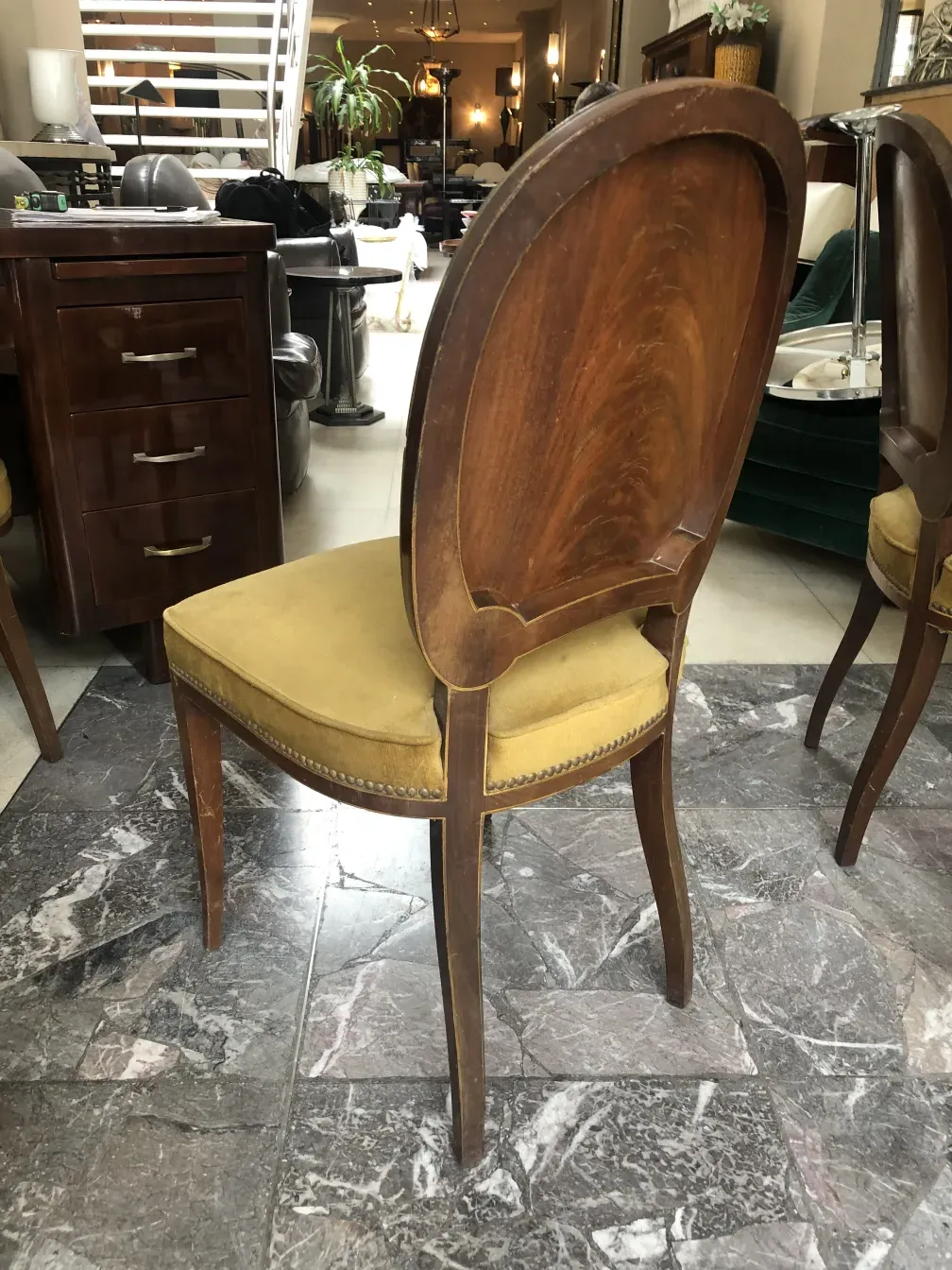 Conjunto de 12 sillas antiguas con diseño clásico Jansen, mostrando un entorno acogedor.