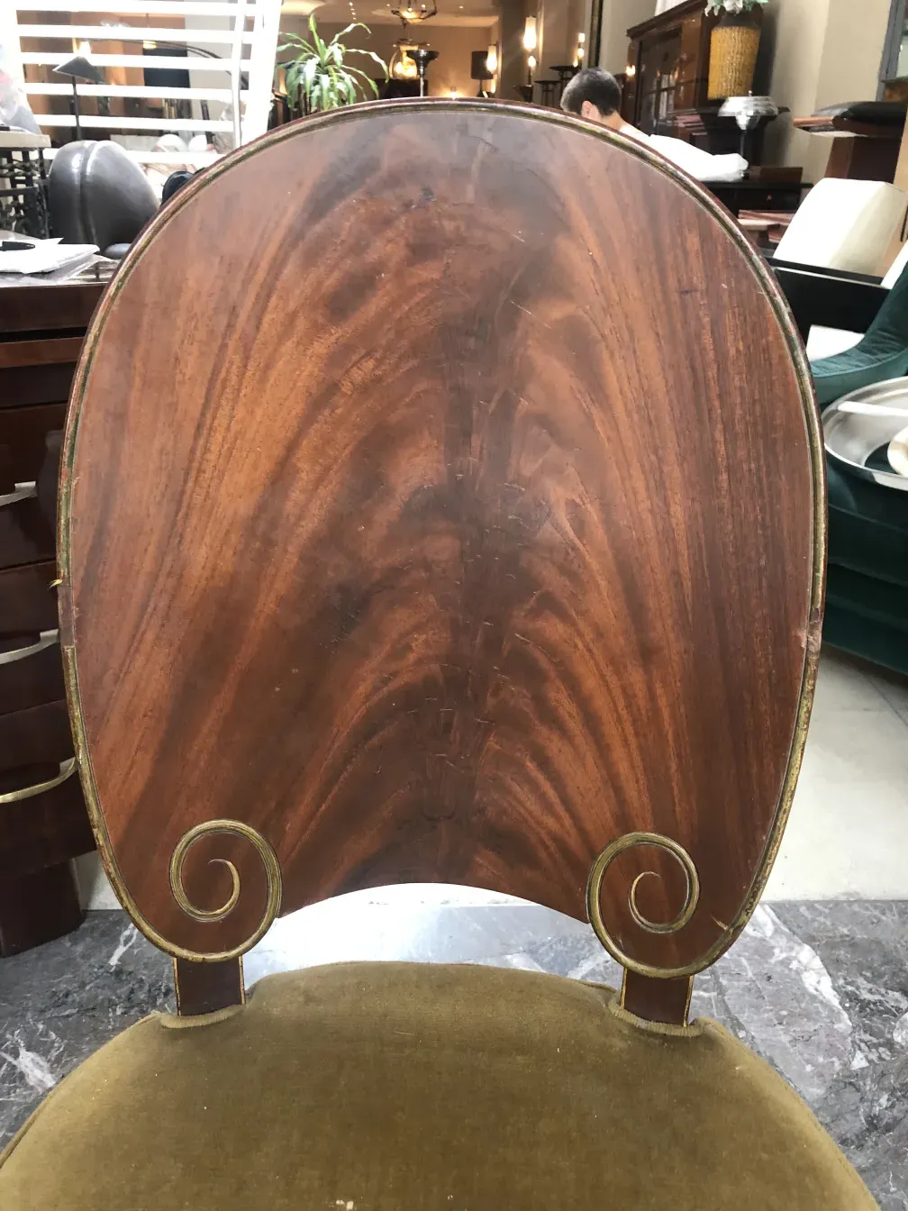 Vista da parte de trás de uma cadeira antiga Jansen com design elegante e detalhes únicos em ambiente de antiguidades.