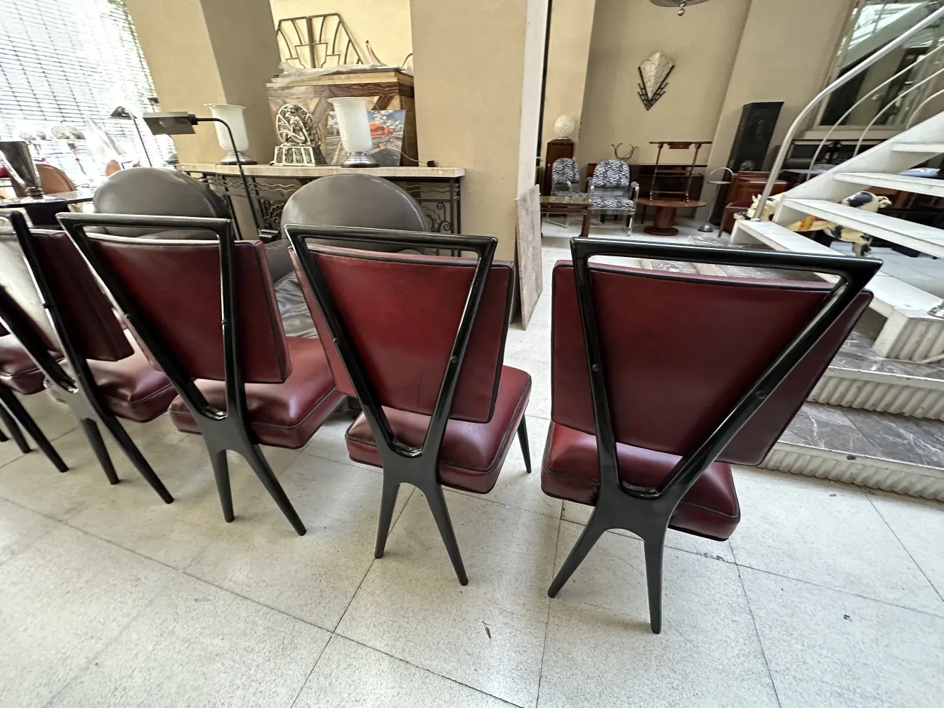 Vista posteriore di 12 sedie antiche con rivestimento elegante in un ambiente di antiquariato