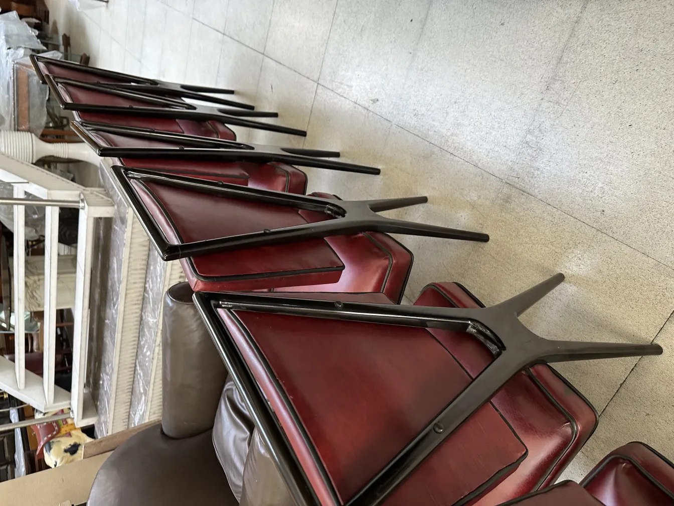 Vista de 12 cadeiras antigas empilhadas, design clássico.