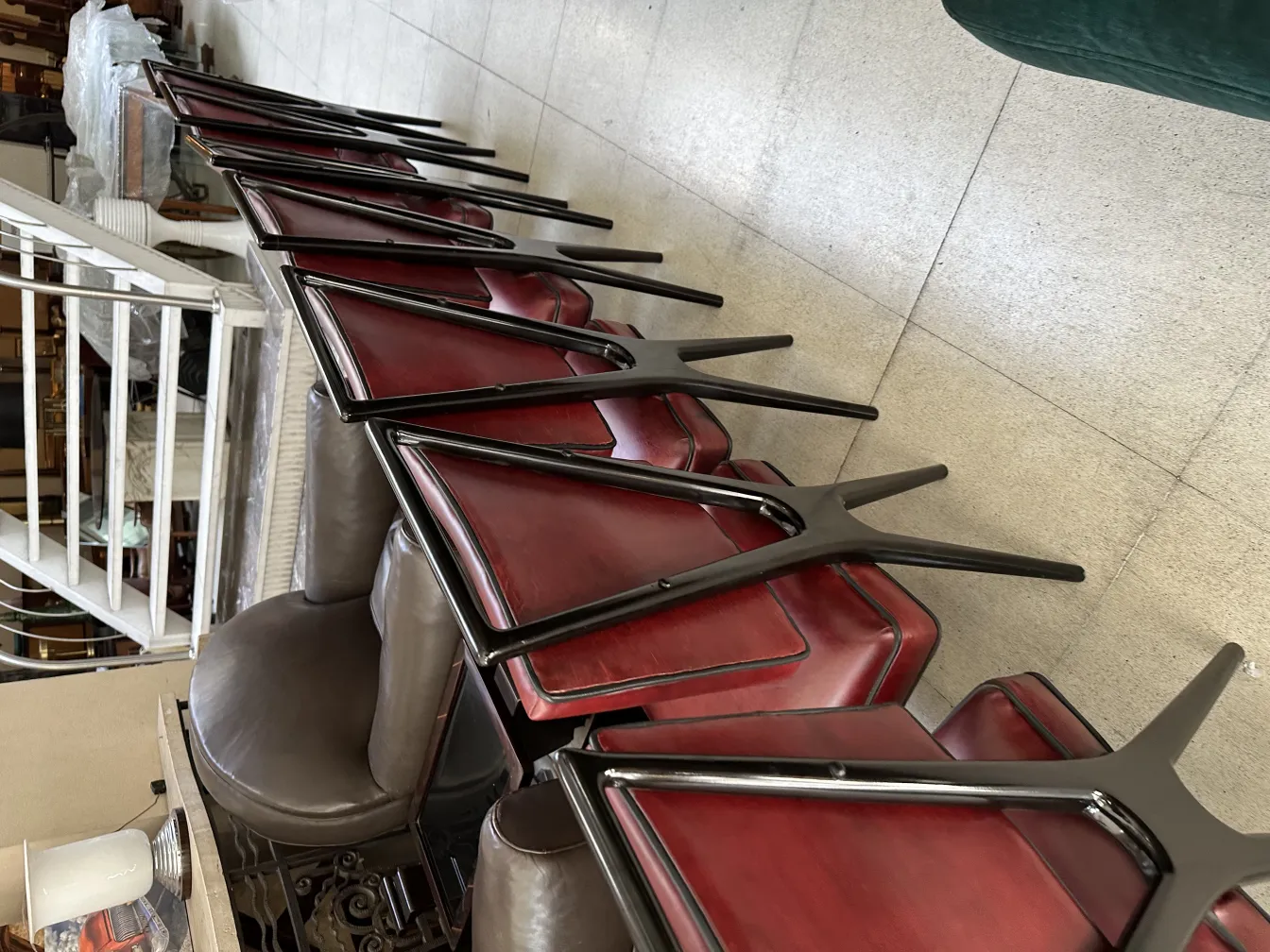 Vista de 12 cadeiras antigas empilhadas em um interior