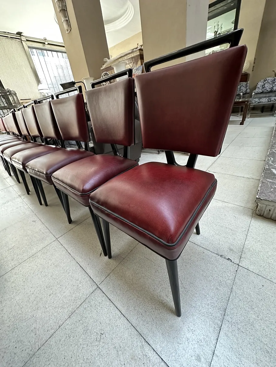 row of 12 antique burgundy chairs in a stylish setting