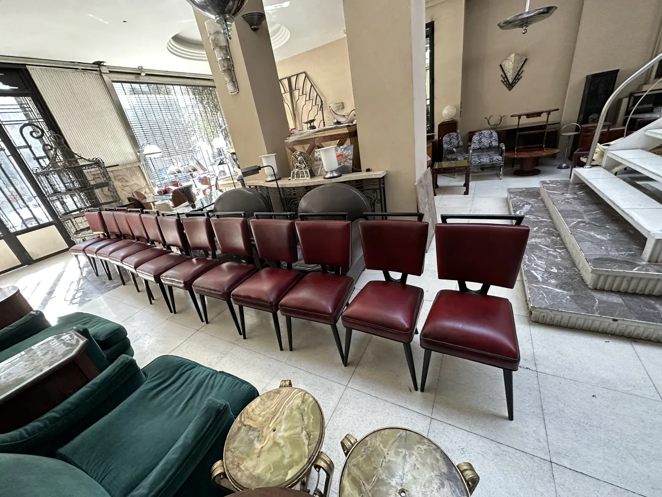 Doze cadeiras antigas vermelhas em um ambiente antigo.