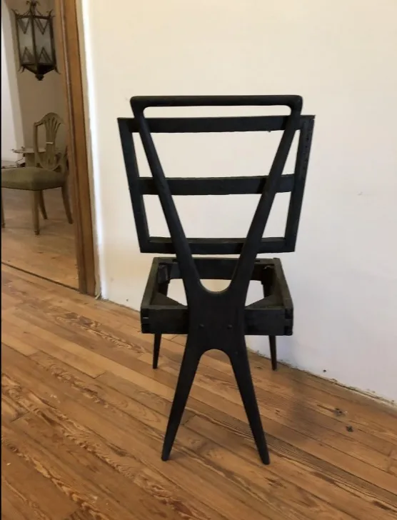 Vue latérale de 12 chaises de design anciennes dans un cadre classique.