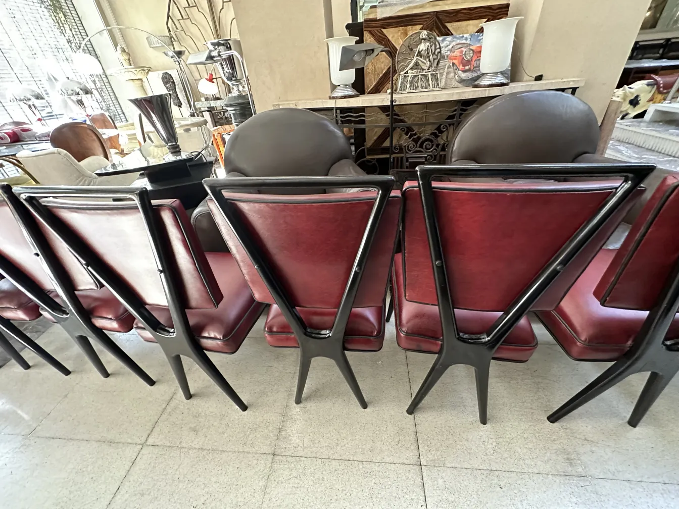 View of the back of 12 antique dining chairs in an elegant setting. Showcases design details.